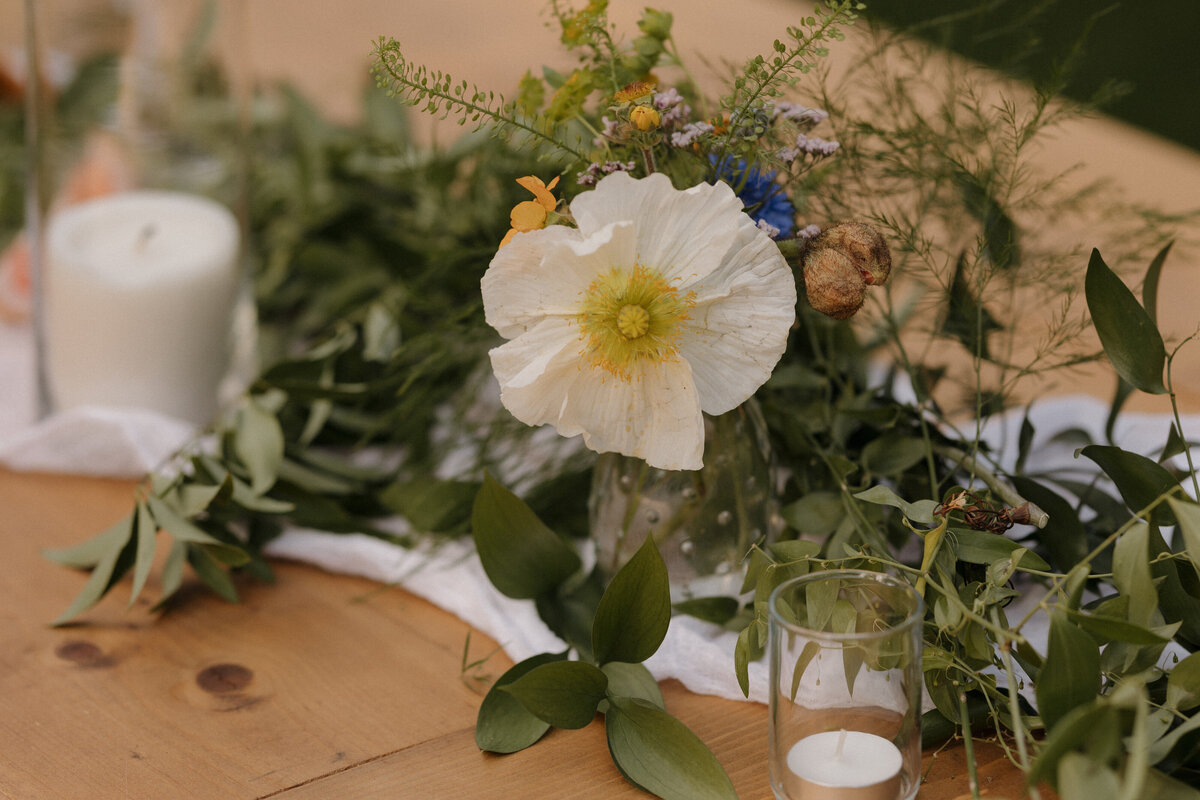 An elegant floral centerpiece, perfectly styled for a romantic Idaho mountain wedding, captured in fine art detail.