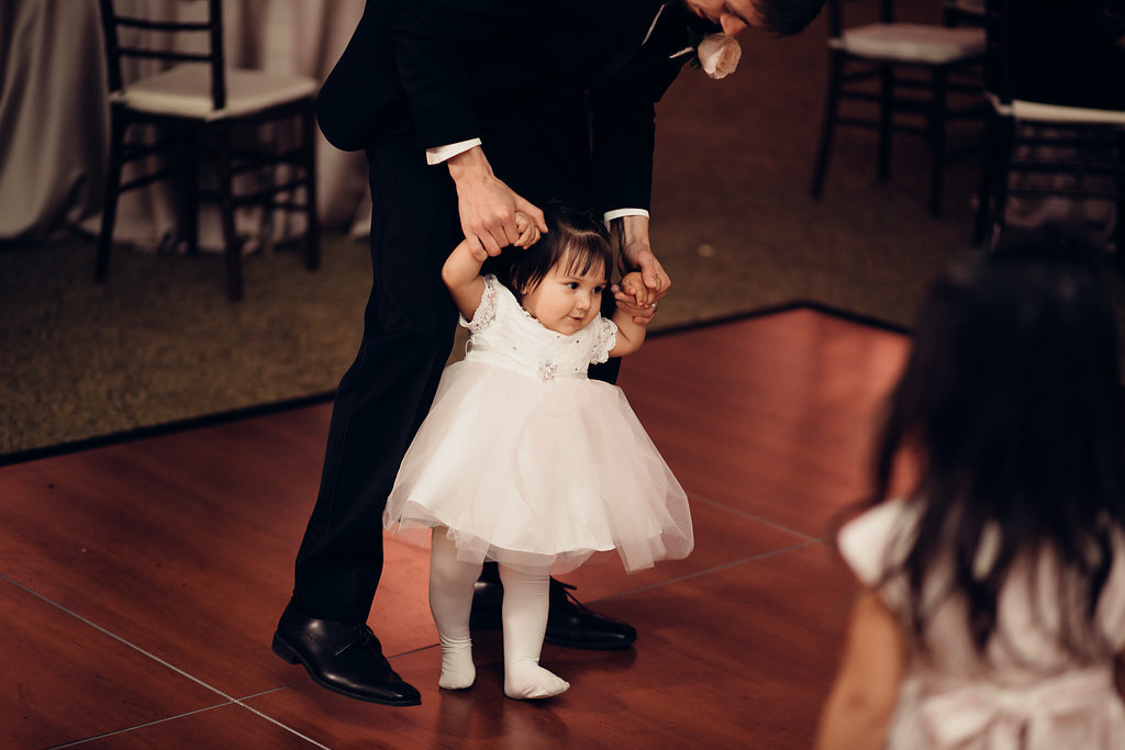 Wedding Photograph Of a Toddler Supported By a Man While Dancing Los Angeles