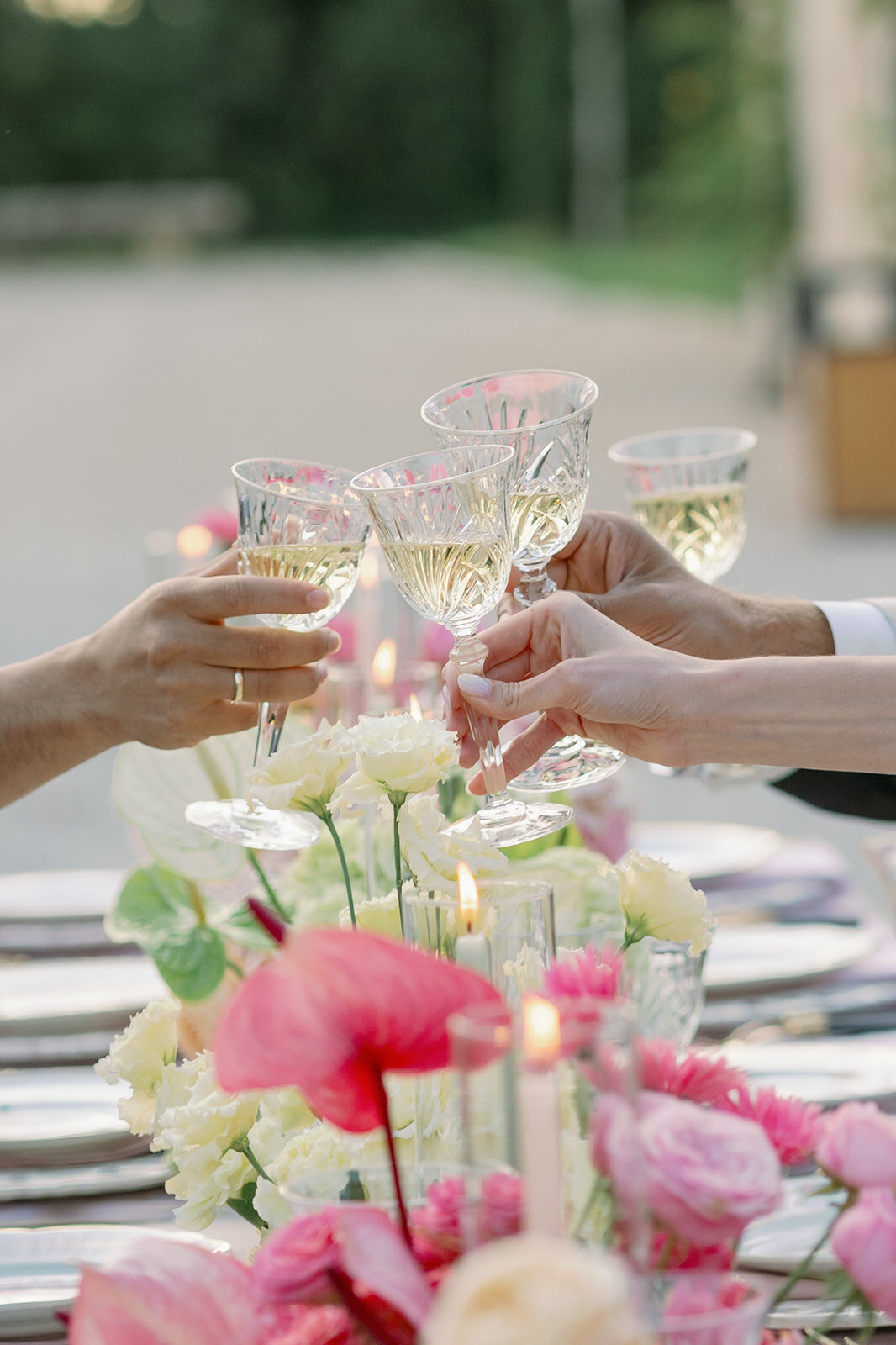 uests raising crystal champagne glasses at outdoor wedding dinner at Château de Tourreau.