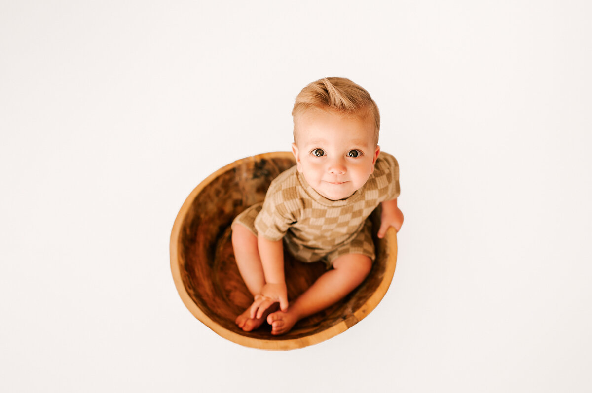 kids photography in springfield MO of baby boy sitting in bowl smiling during 6 month milestone session