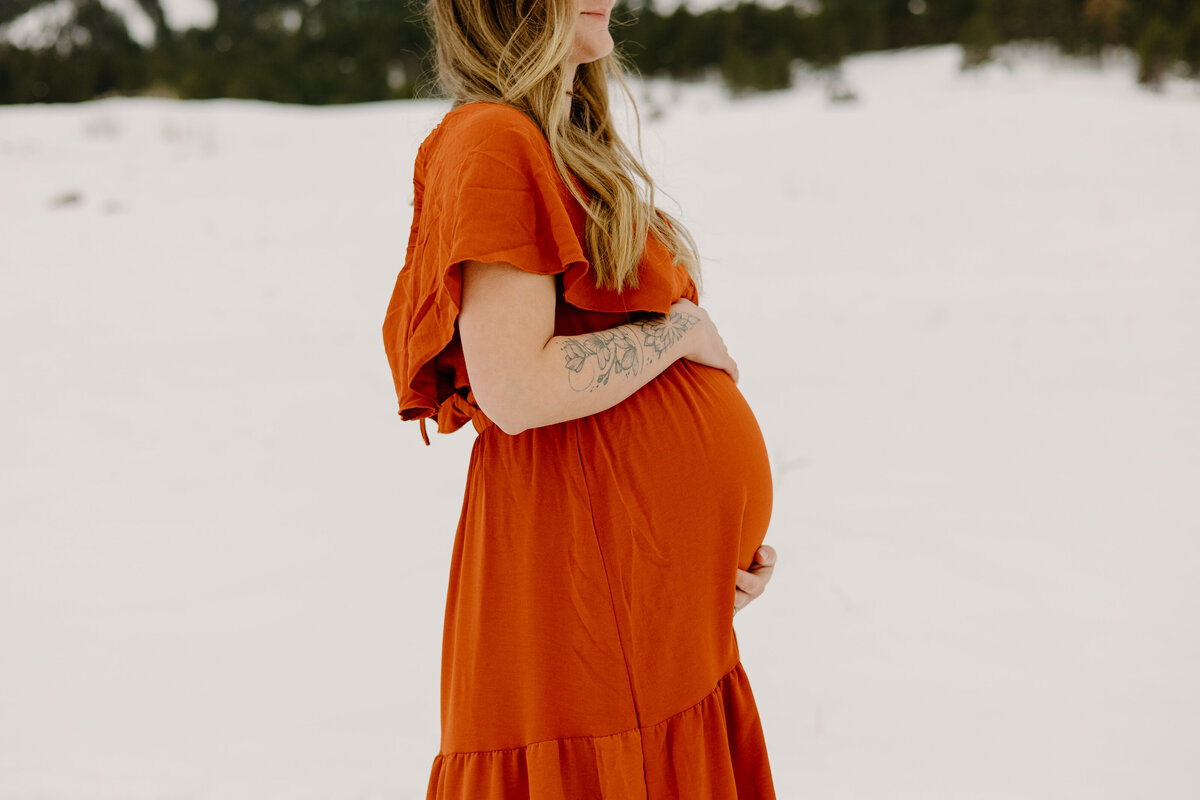 A new mother poses for a photo in the snow in Boulder, Colorado.