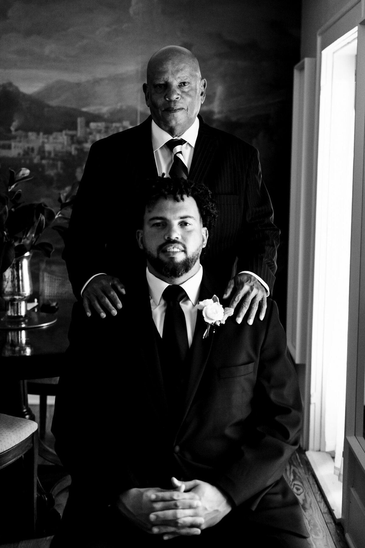 A father standing behind his son the groom at a wedding for a portrait 