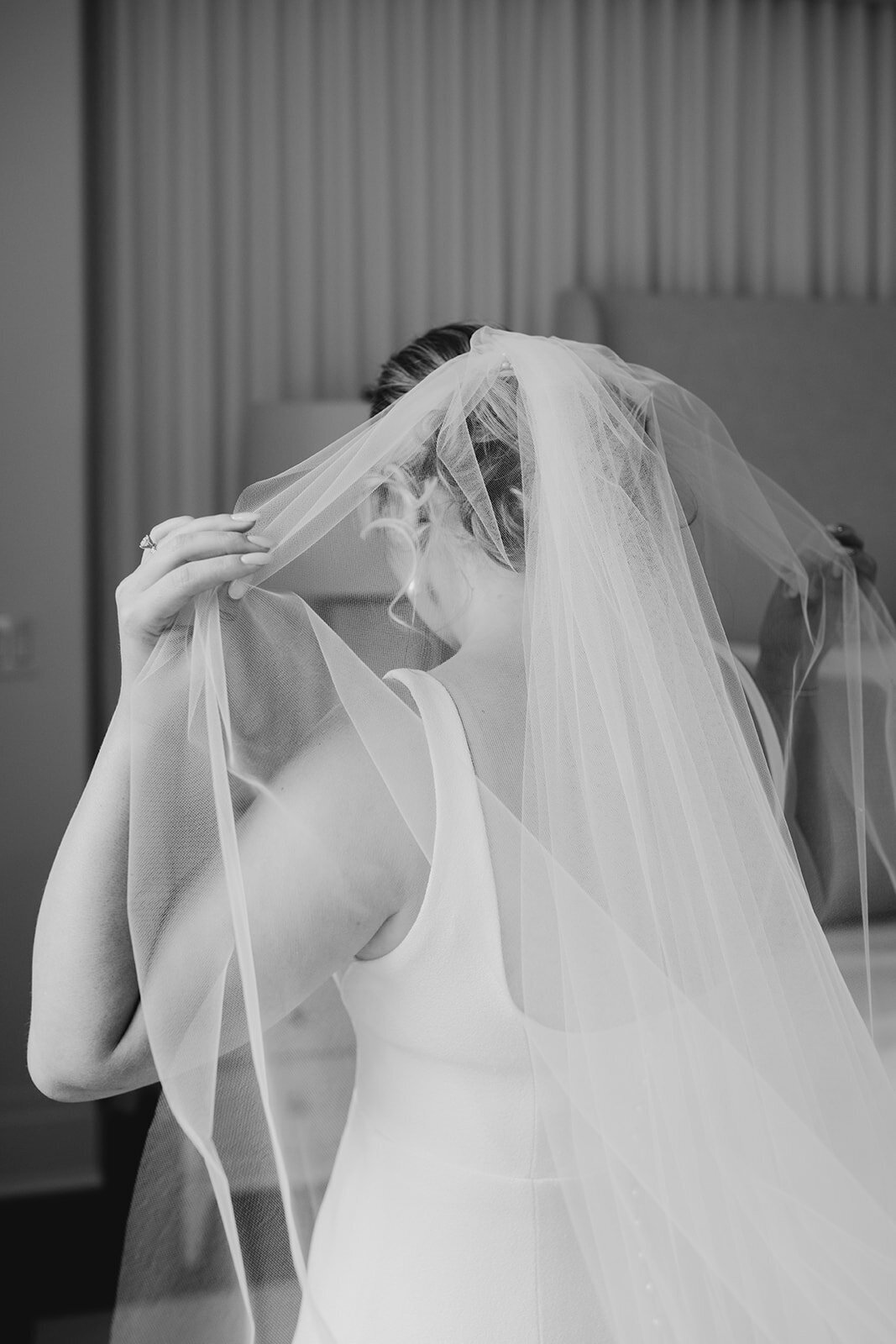 Bride putting veil on
