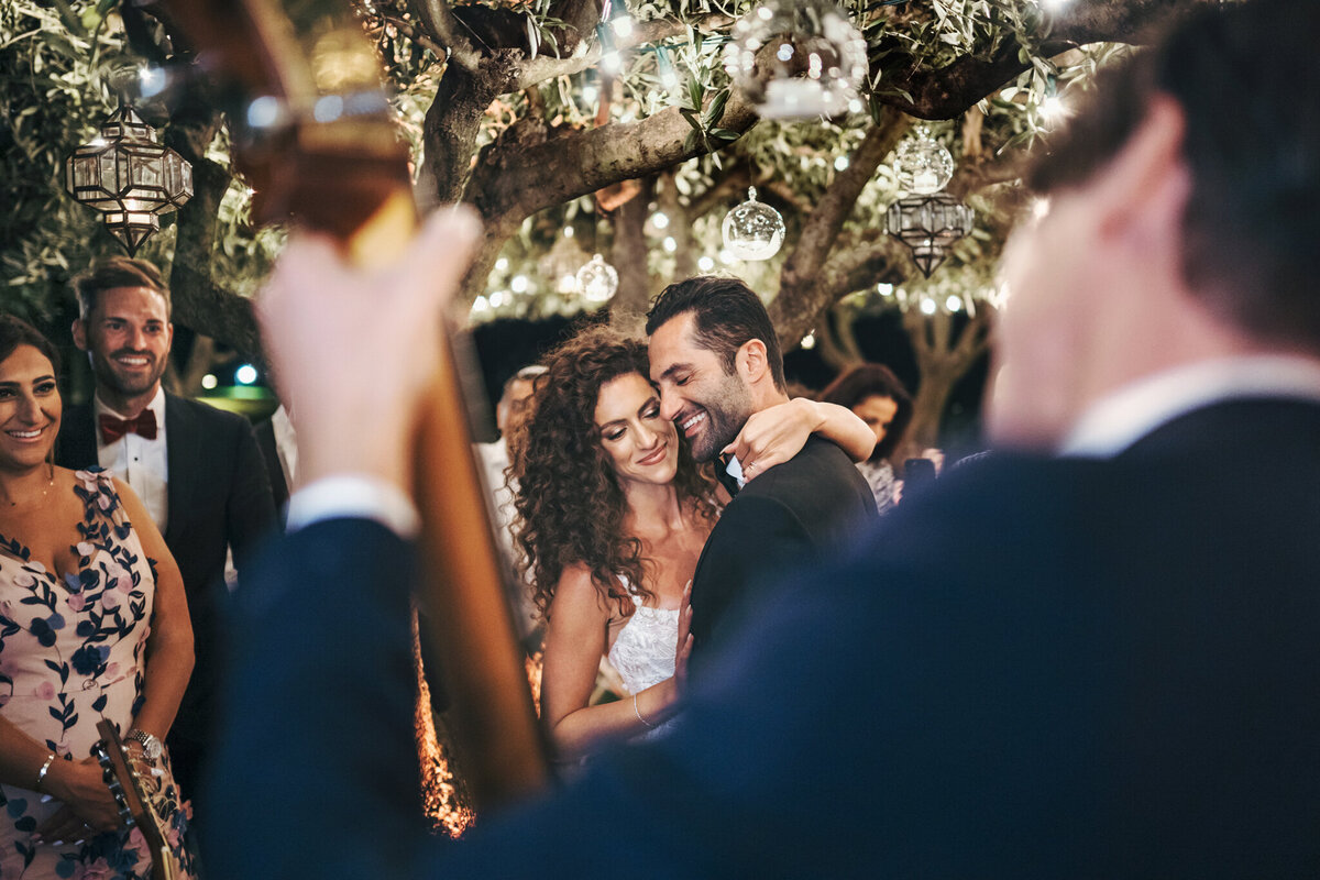First newlyweds dance under olive trees at destination wedding in Iatly