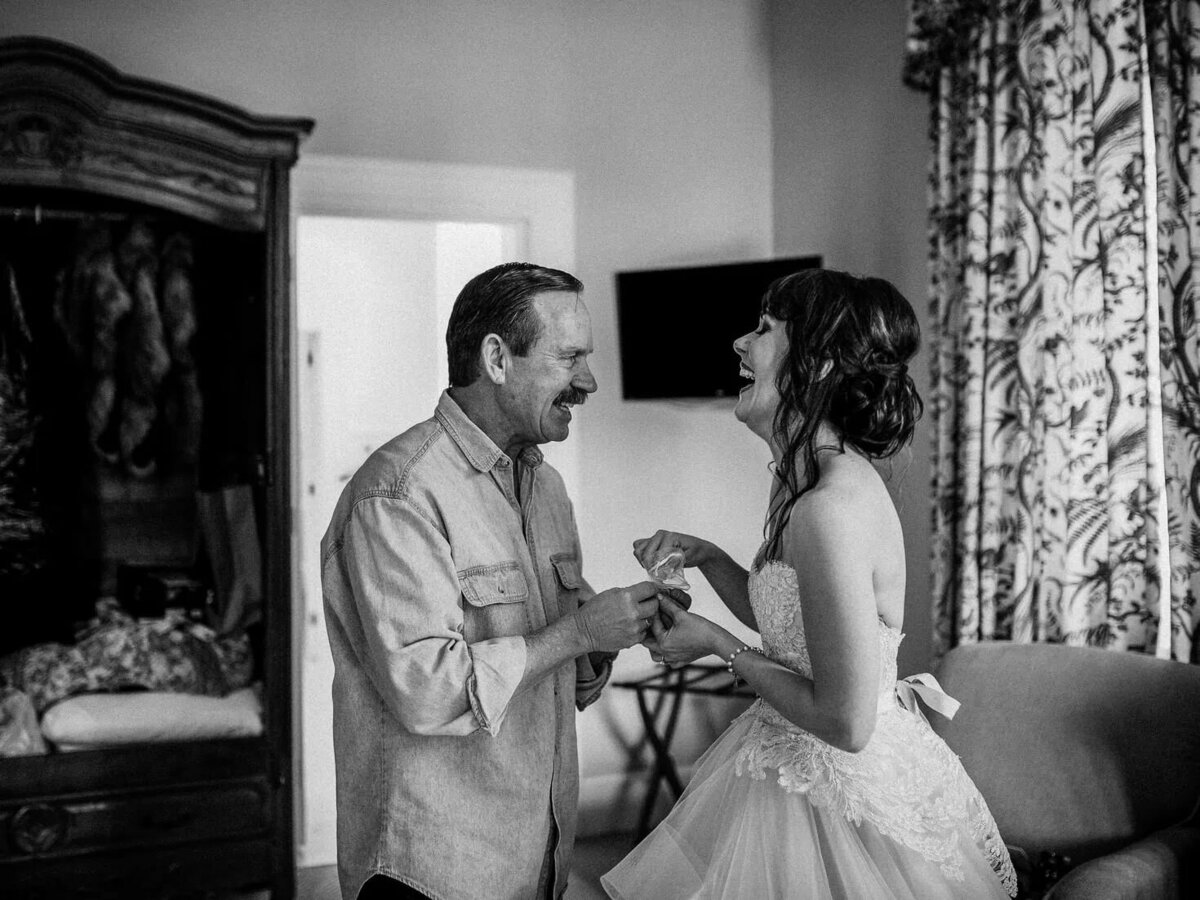 A bride laughing with an older man.
