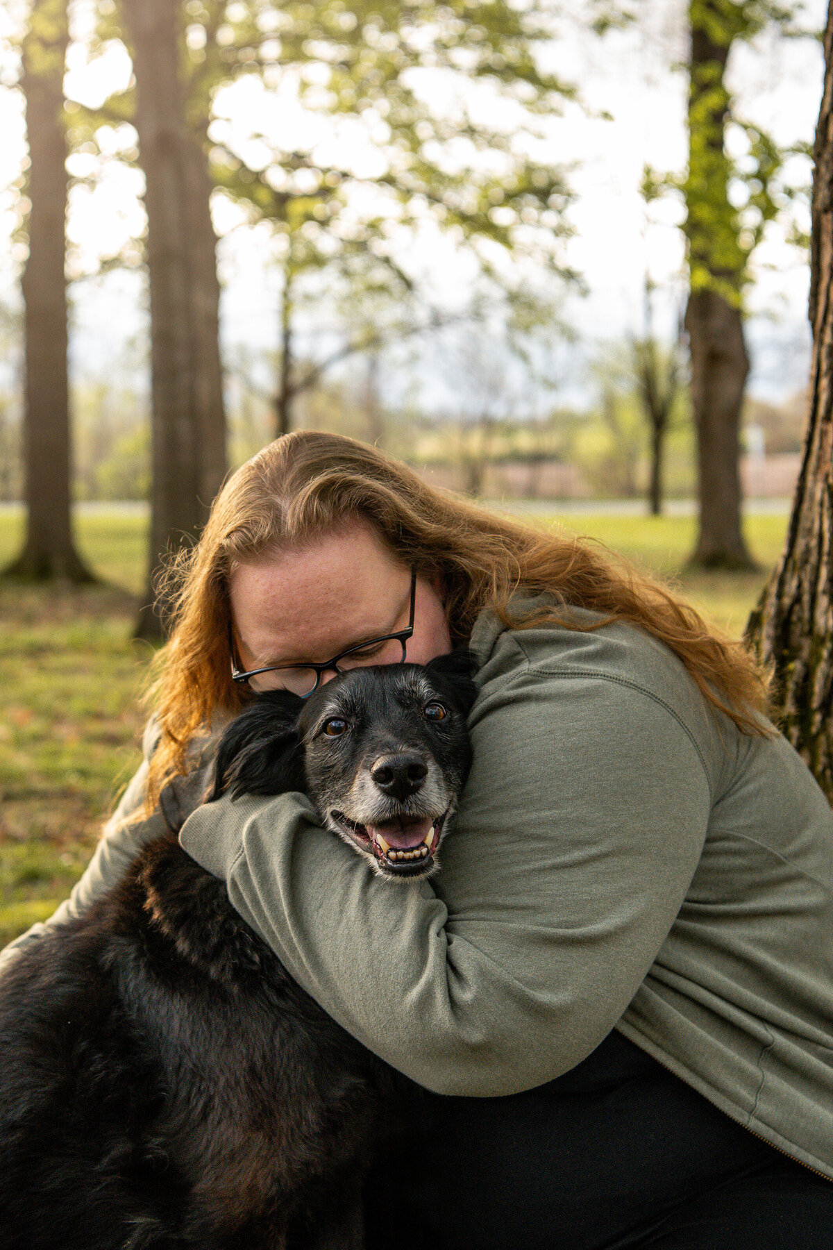 Owner hugging older black dog during a photoshoot. Work by Duluth-based pet photographer Joanna of Paddle Paws Photography.