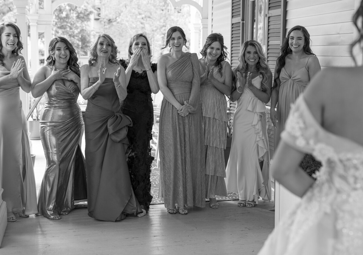 Bridesmaids react joyfully after seeing Bride.