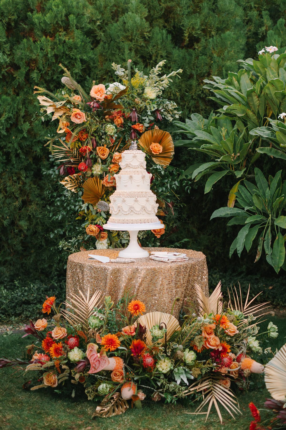 White and gold lambeth wedding cake on sequin table.