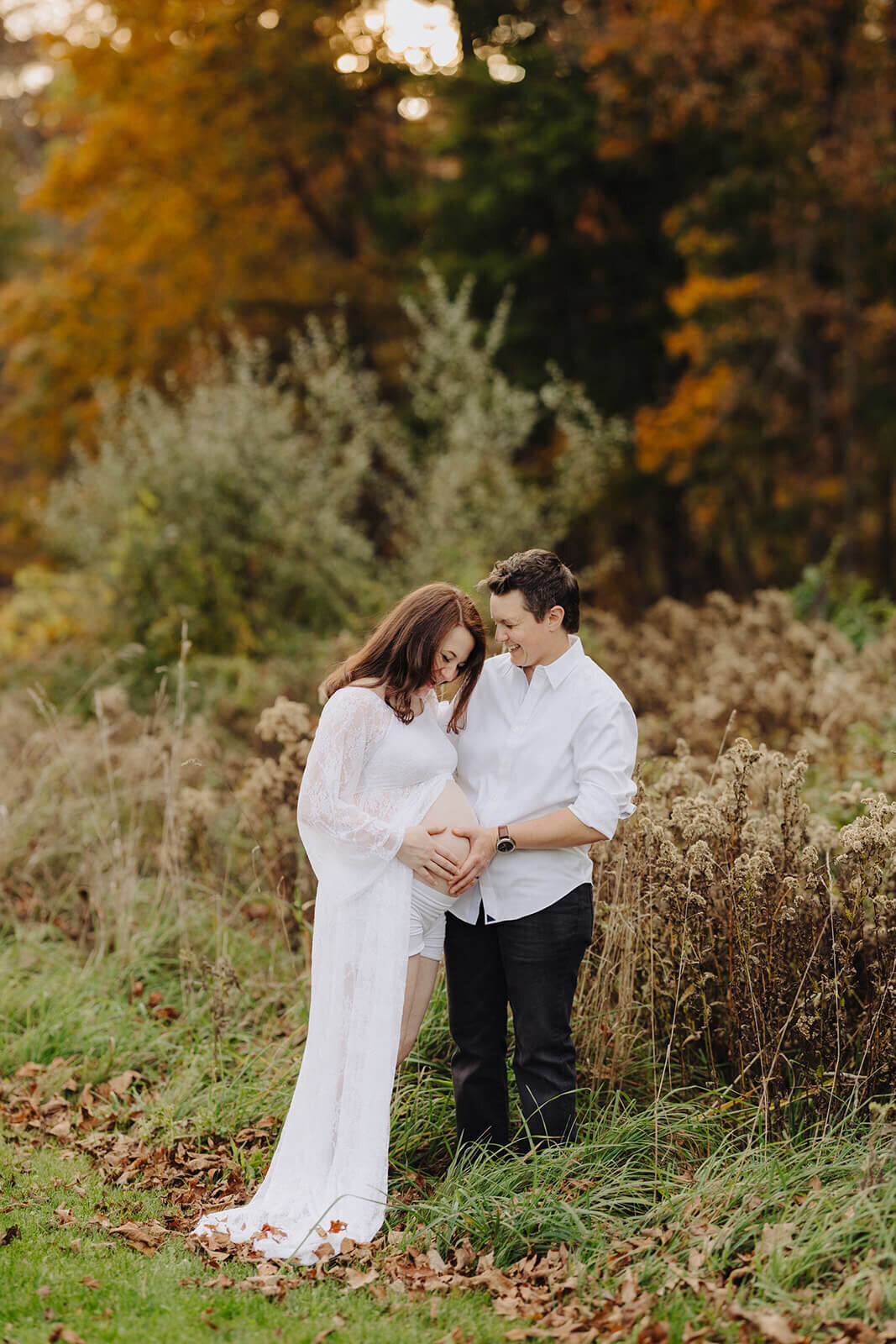 Maternity session with couple resting hands on baby bump at Finger Lakes, NY