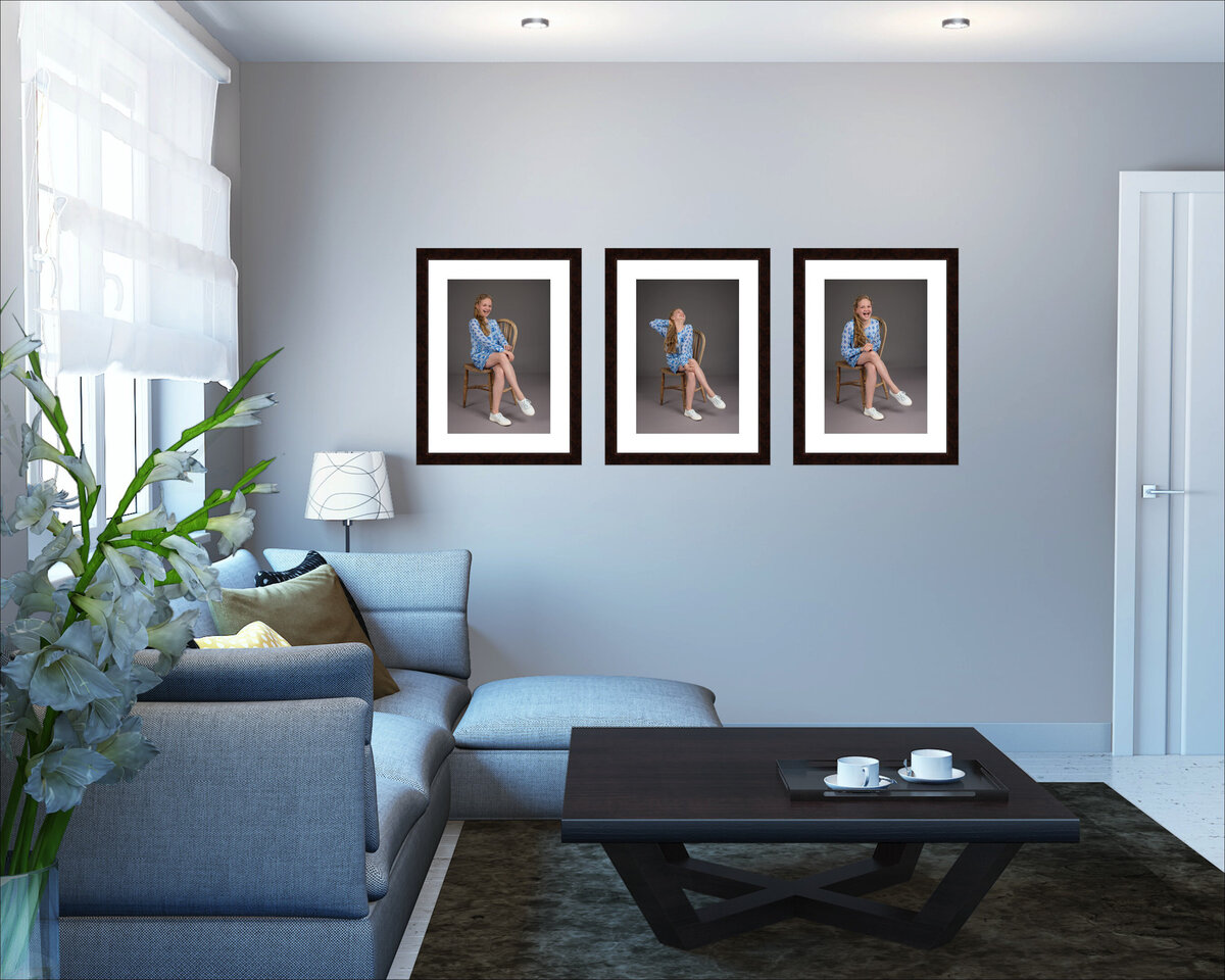 A living room with blue tones and a triptych of pictures hanging on the wall of a girl dressed in blue sitting on a chair in different poses.