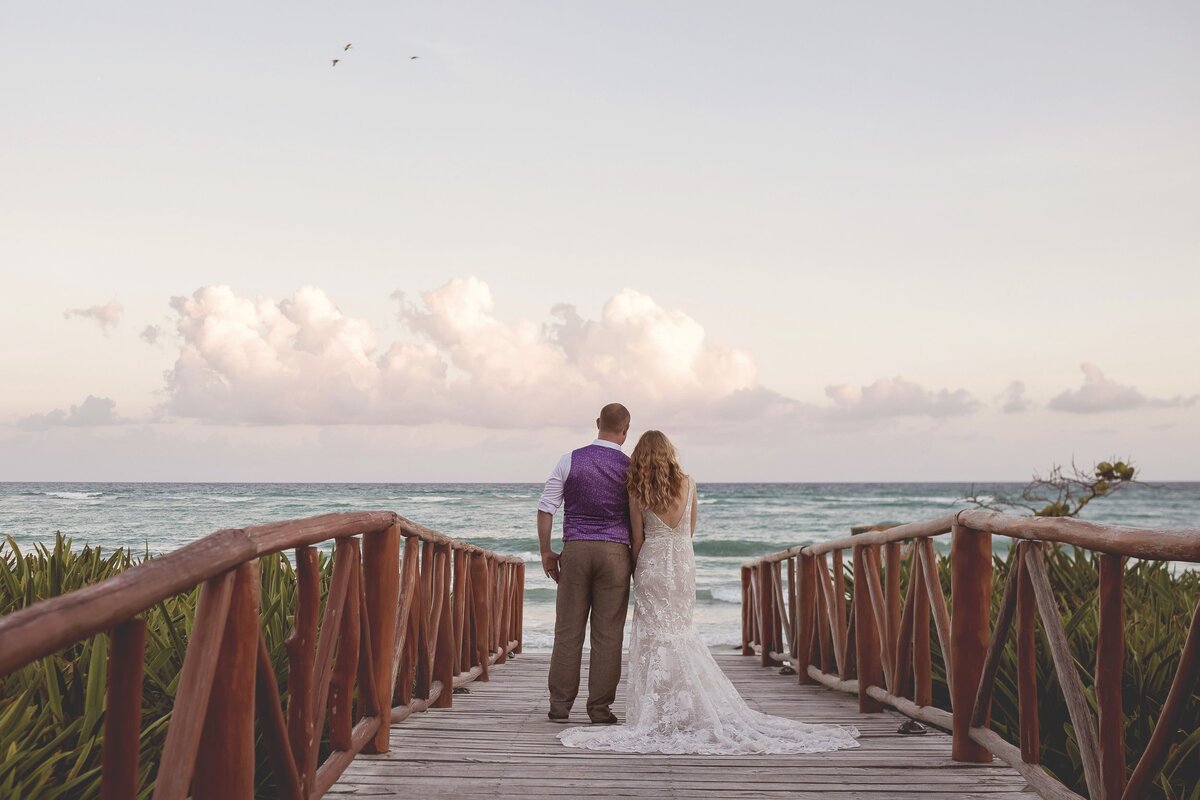 Bride and groom on path in front of sea at Riviera Maya wedding