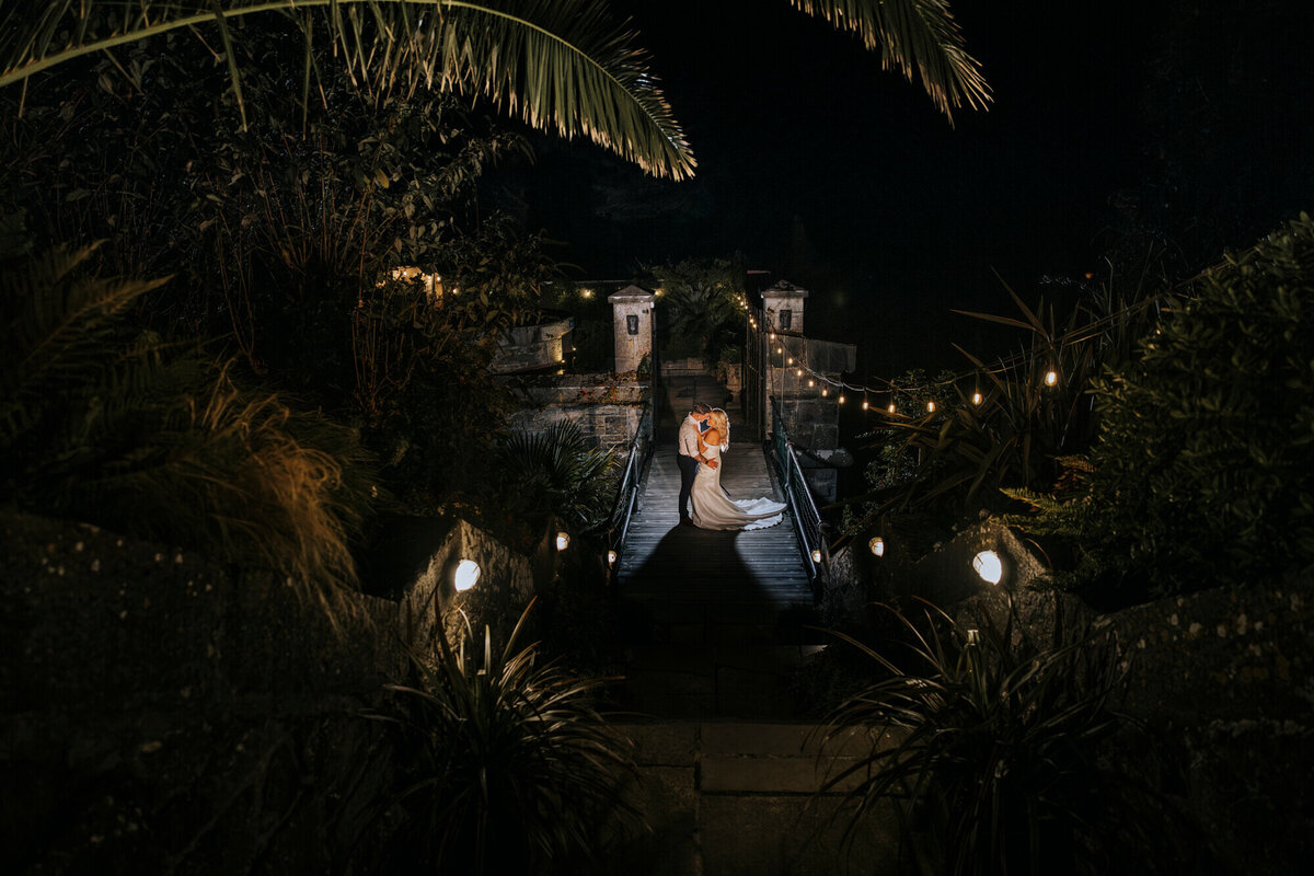 A bride and groom walking down a path at night