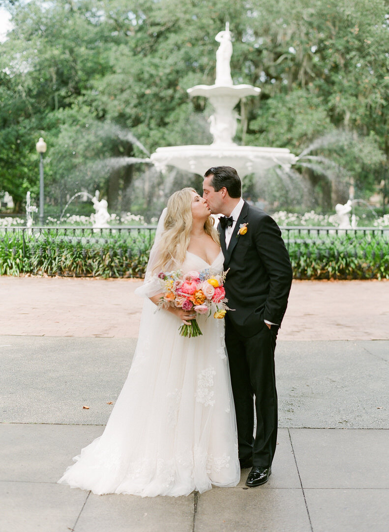 Bride and Groom Kissing in Forsyth Park in Front of Fountain Photo