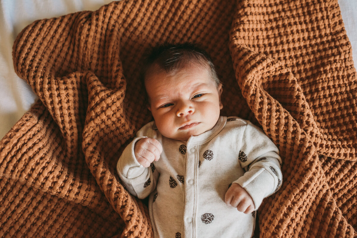 newborn baby laying on bed