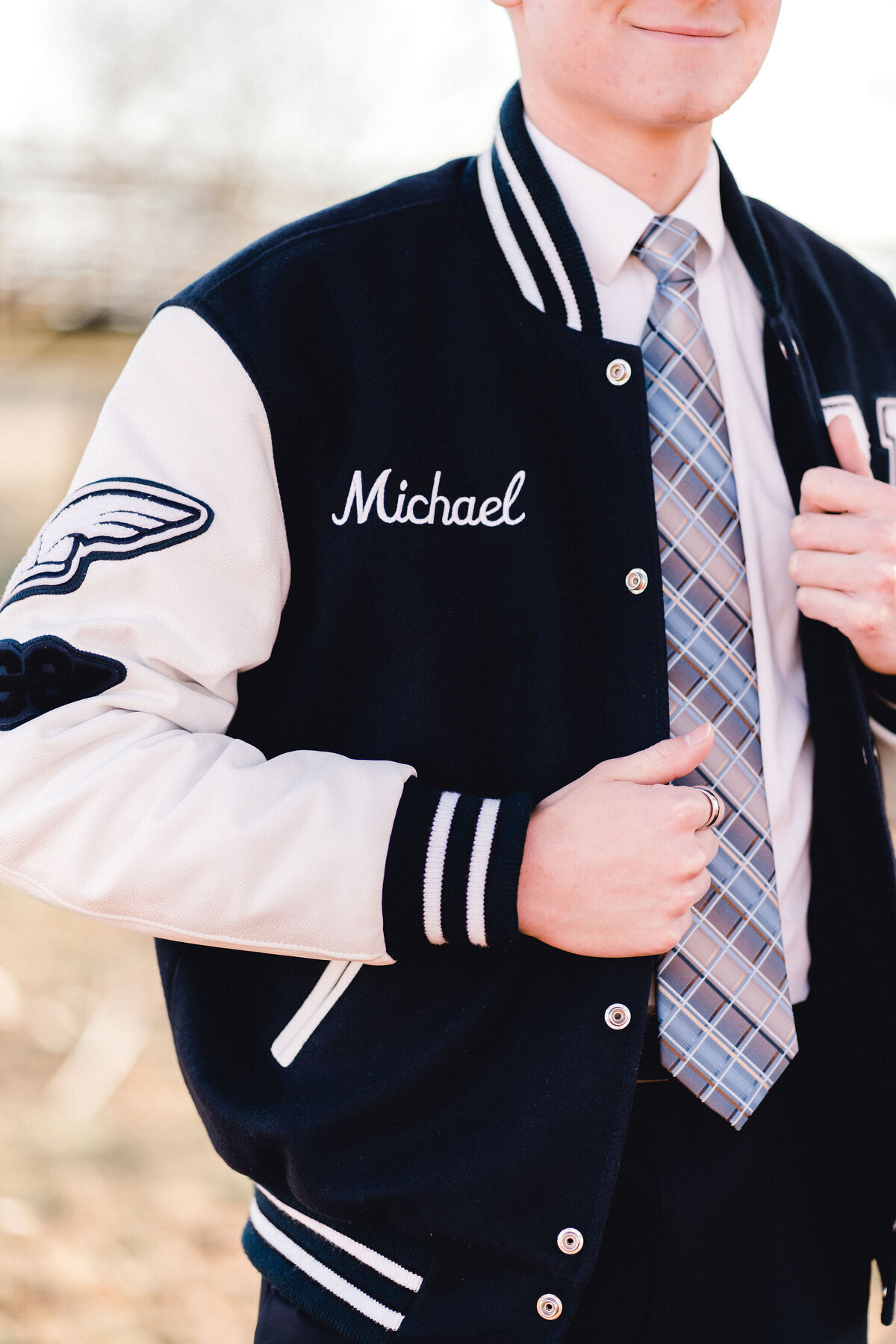 Austin senior boy in letterman jacket. Outside in Austin Texas.