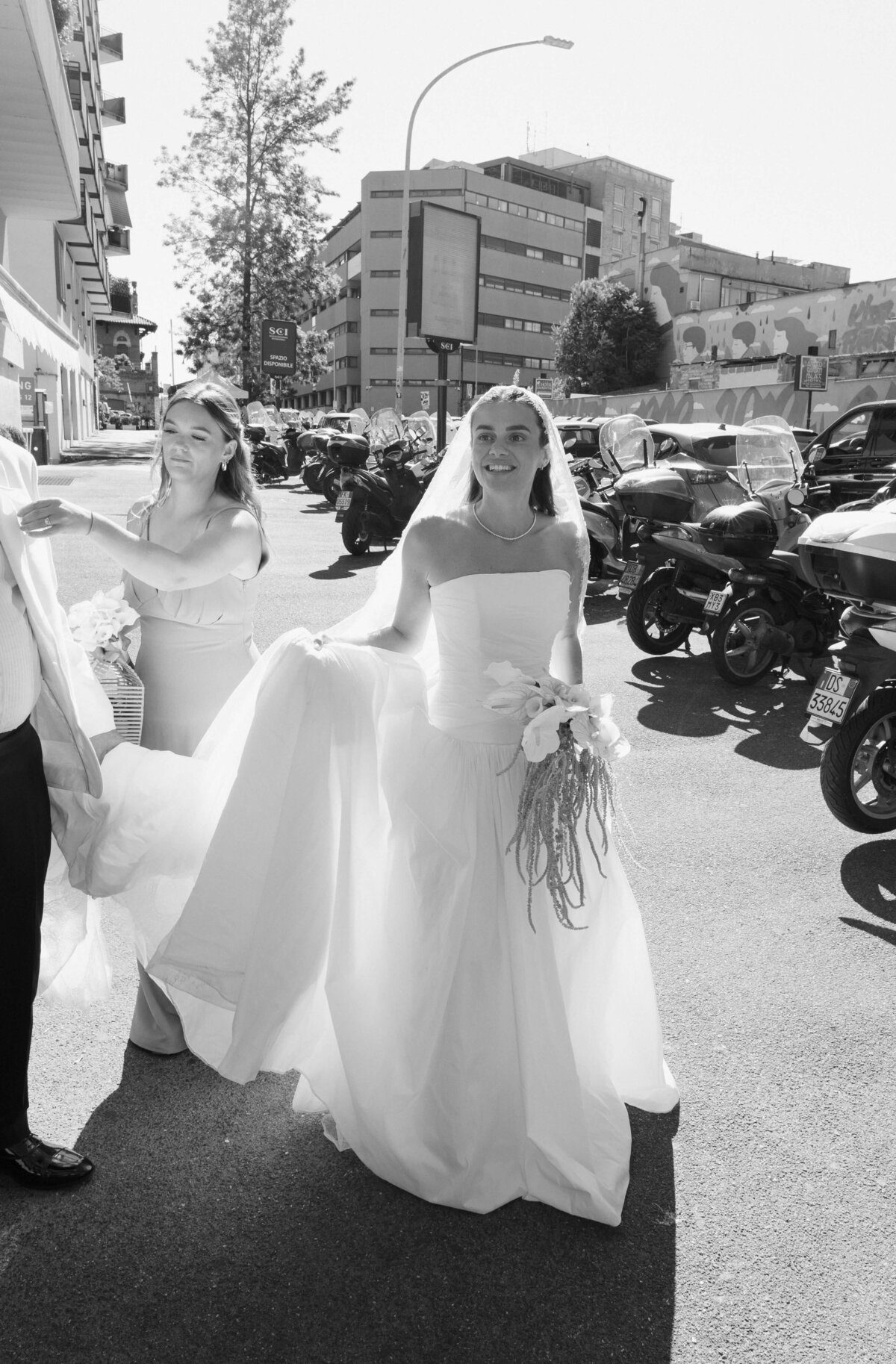 Bride walking through city street with bridesmaids in Rome

