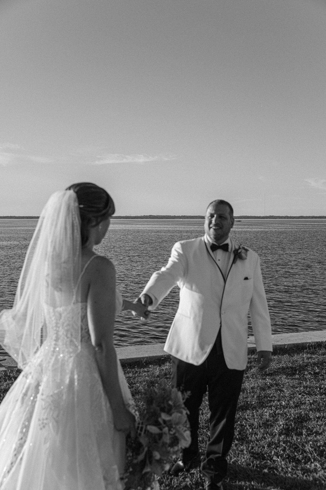 groom holding brides hand and walking backwards