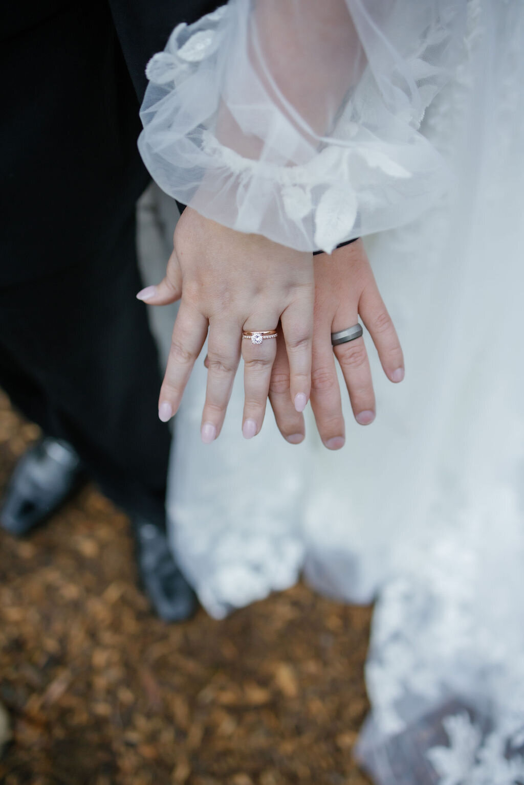 detail photo of bride and groom holding their hands out together to show their wedding rings together captured by gatlinburg photographers