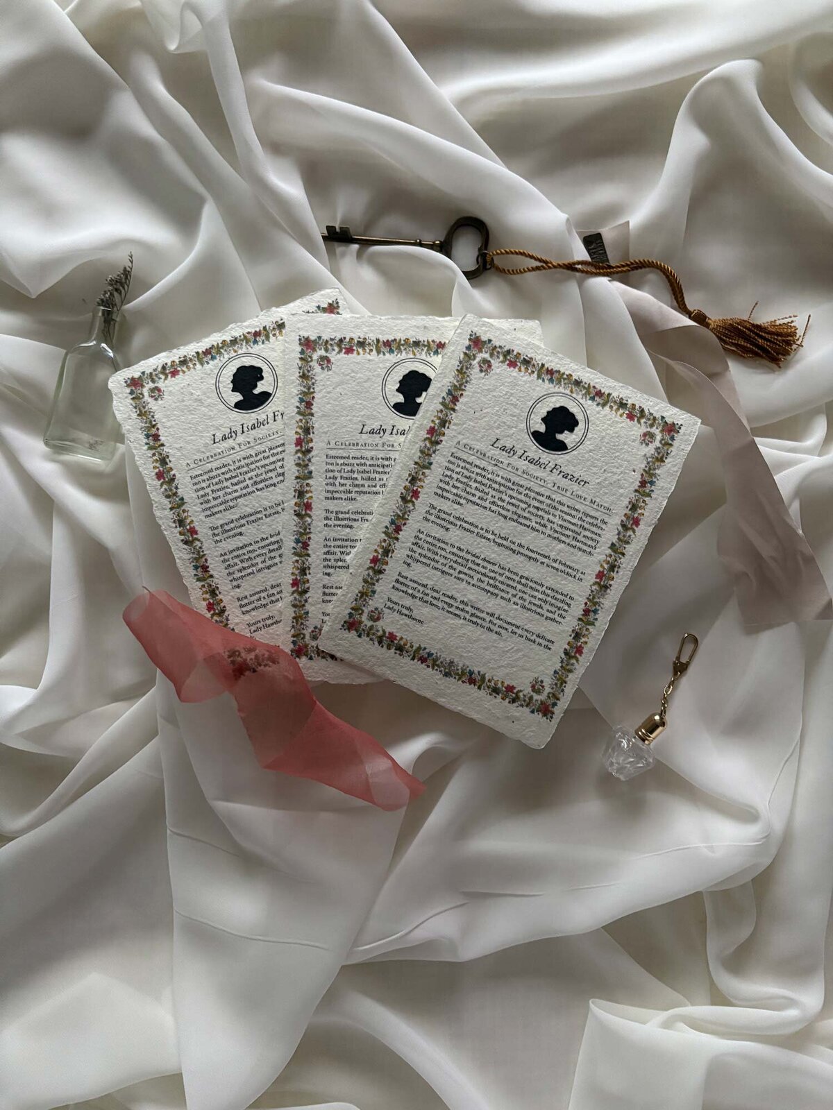 Handmade paper invitations flatlay with authentic silk ribbon