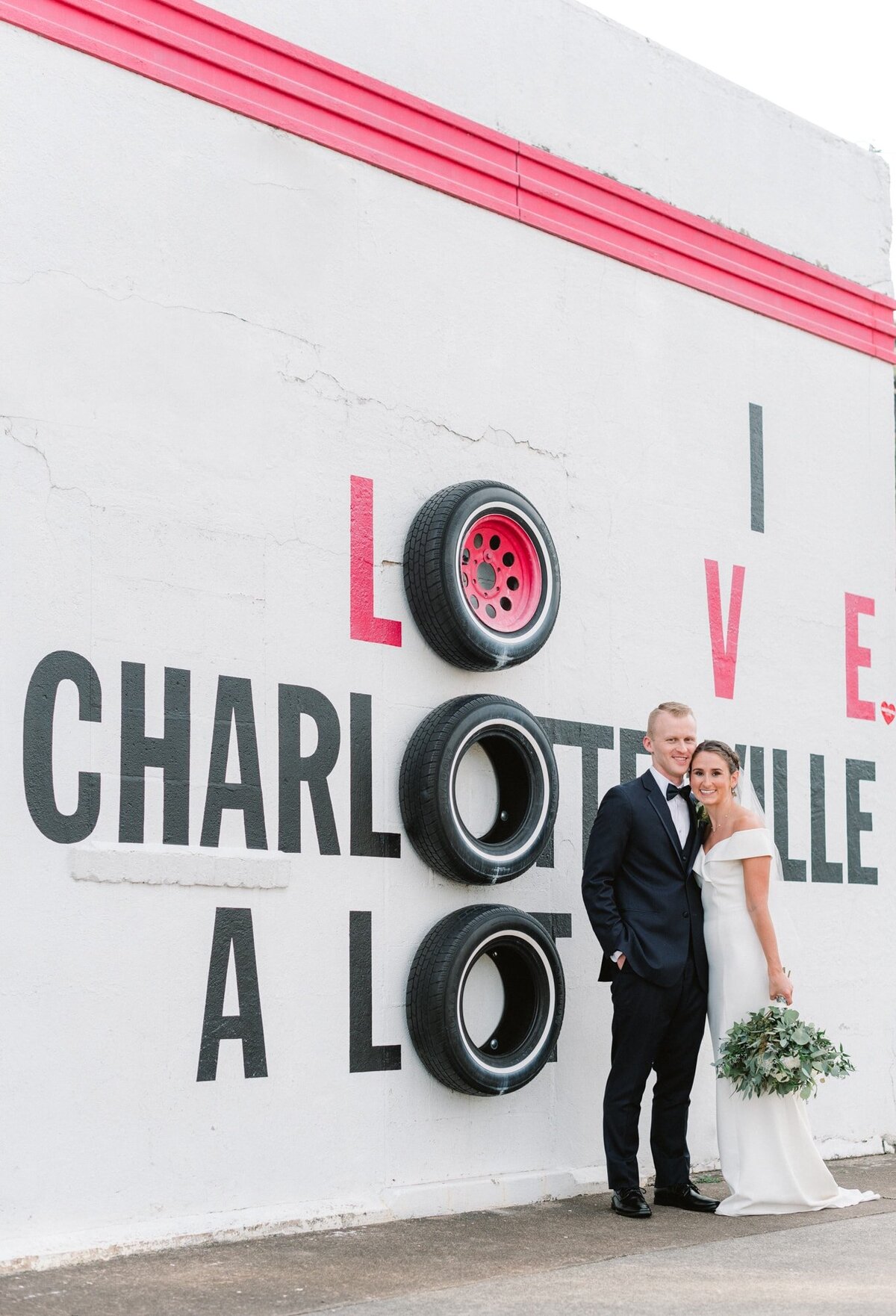 Bride and groom smile in front of I Love Charlottesville A Lot sign