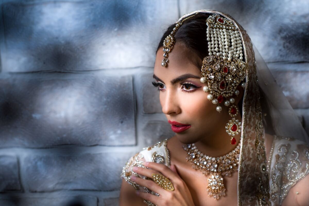 Stunning Indian bride in Ottawa featuring traditional kohl-lined eyes and a vibrant red lip for her ceremony.