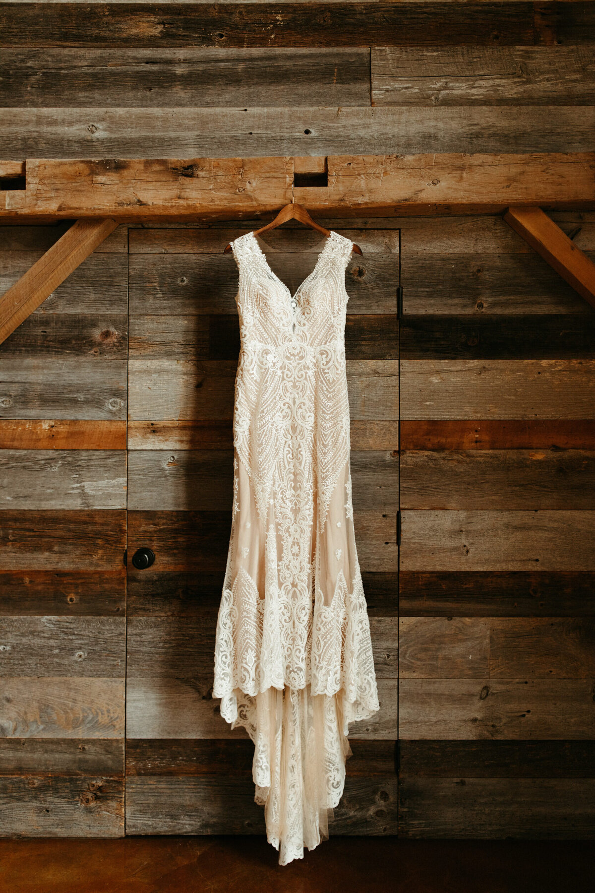 Vintage wedding dress hanging on wooden wall