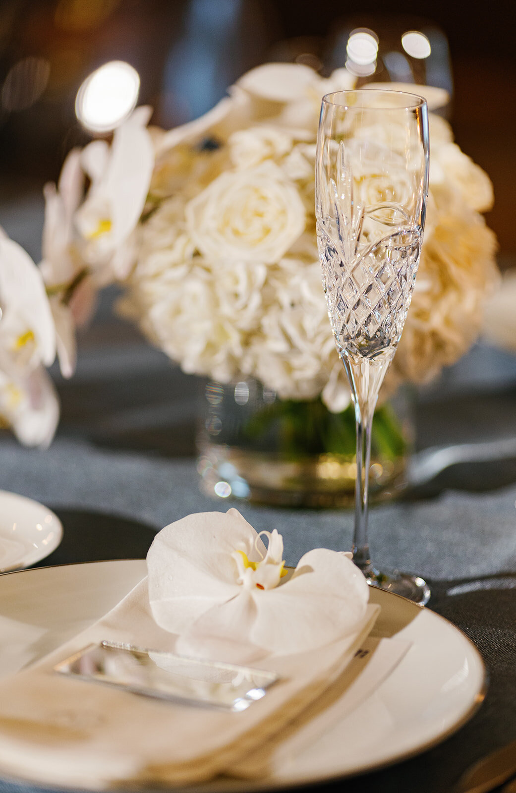 A crystal champagne glass elegantly placed on the reception table, surrounded by delicate white flowers at Ocean Reef, Key Largo.