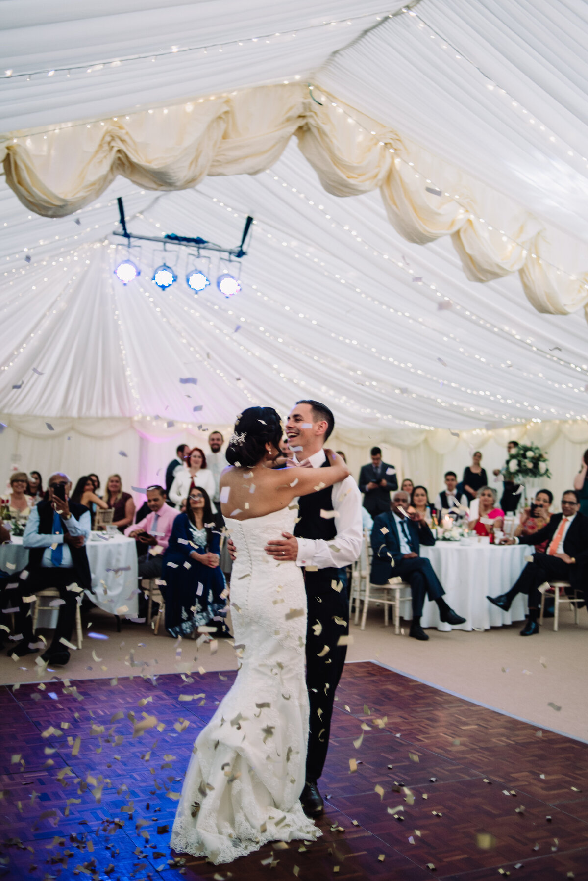 A couple dancing together with confetti falling around them taken by London Wedding Photographer Liberty Pearl