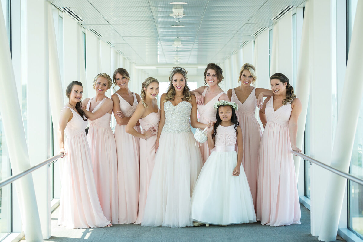 Bridesmaids in pink dresses with flower girl.