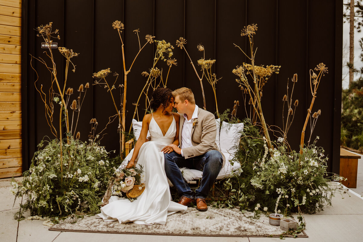 married couple on bench with greenery