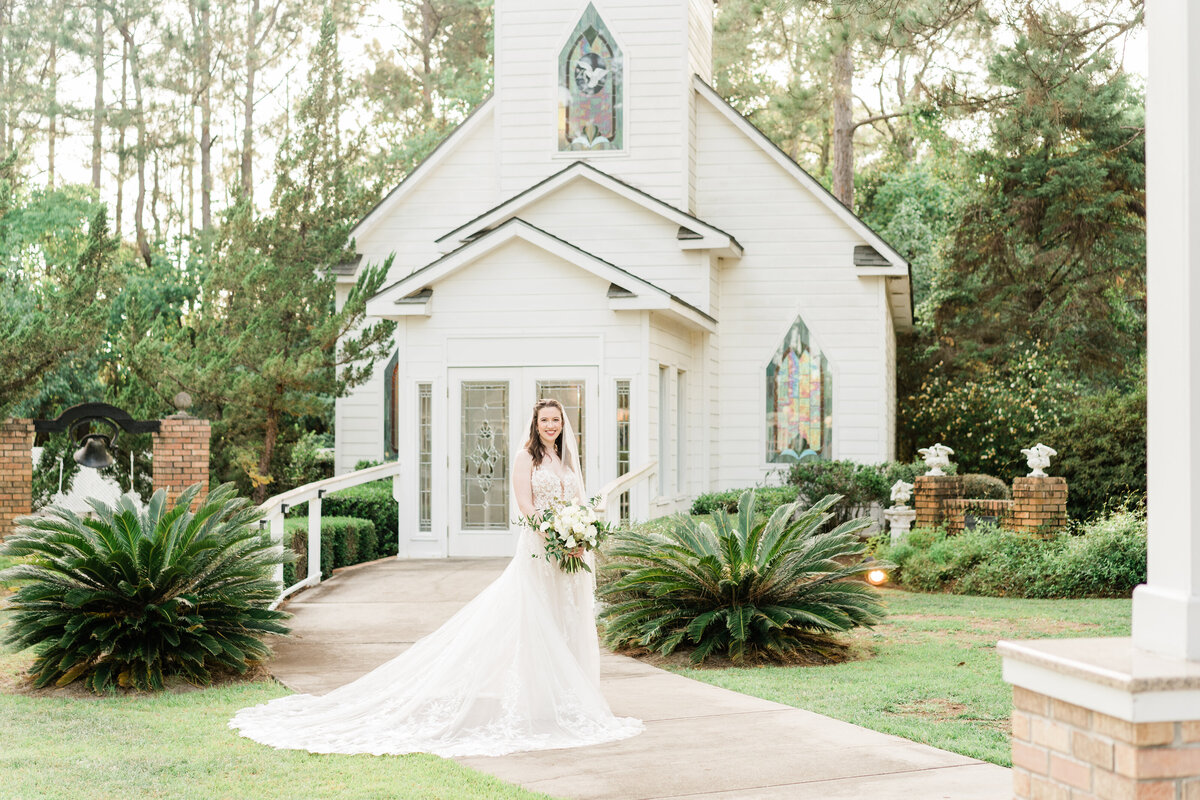 Bride in front of small white church in Alabama