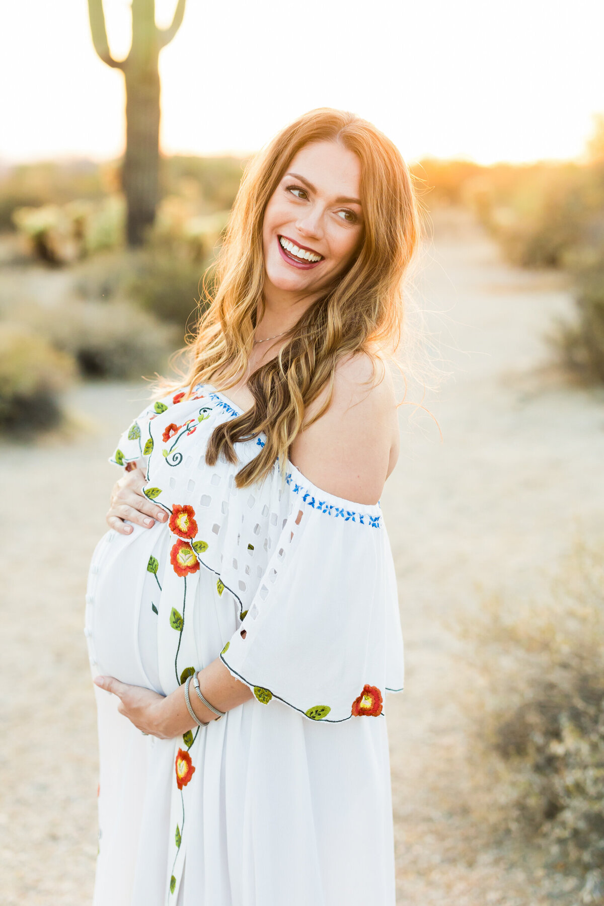 pregnant woman smiling for Scottsdale desert maternity photo session