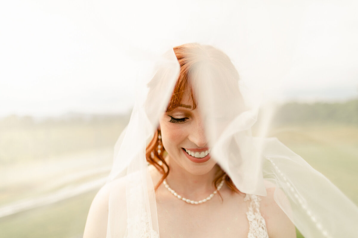Wedding Photographer a bride smiles beneath her her veil