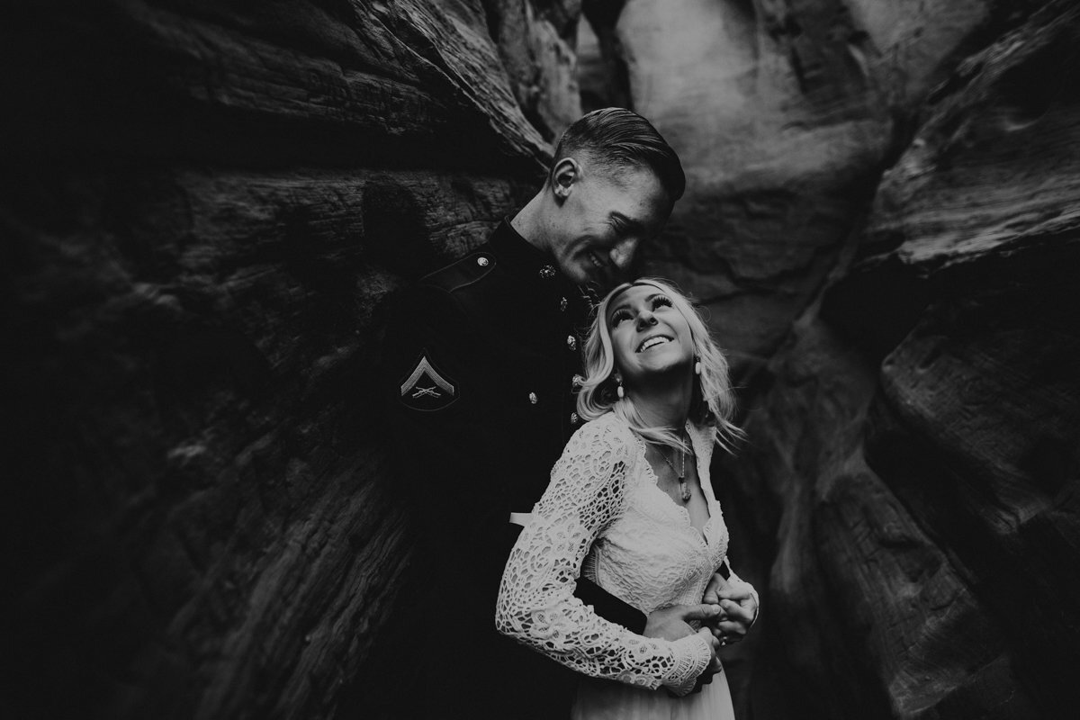 husband and wife smiling in desert canyon