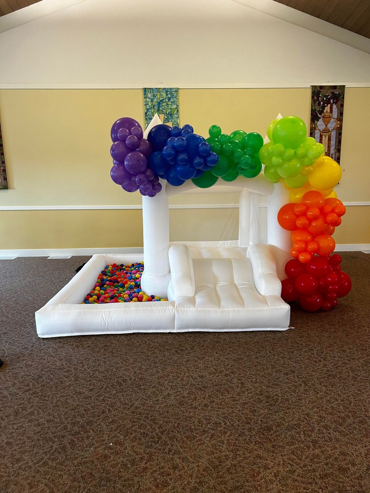 BOUNCE HOUSE INFLATABLE WITH RAINBOW BALLOON GARLAND