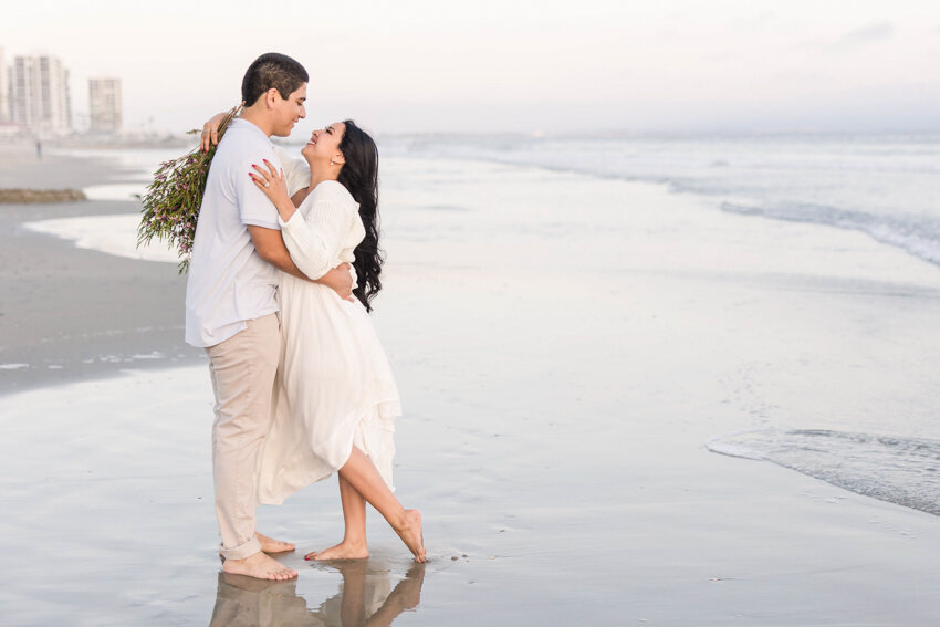 engaged-couple-hugging-on-coronado-beach