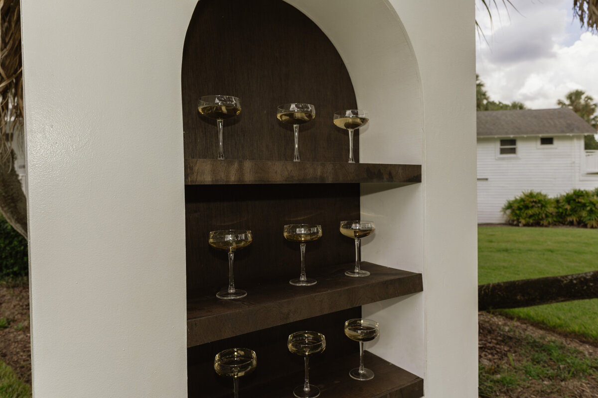 Champagne shelf display with gold accents at a luxury backyard wedding in Umatilla, Florida