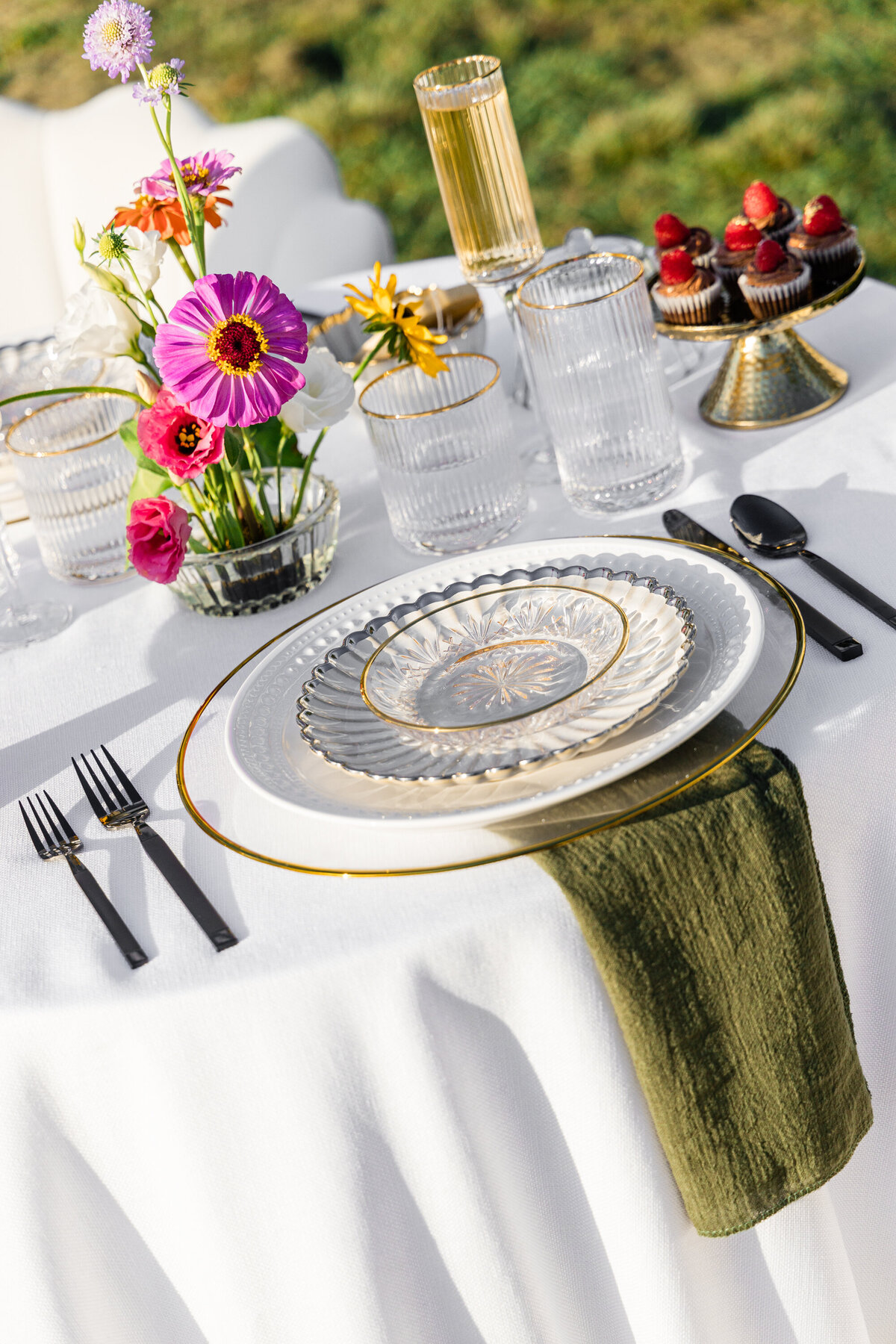 pink orange and white flowers on white table cloth with mixed metal place setting and mini chocolate cupcakes