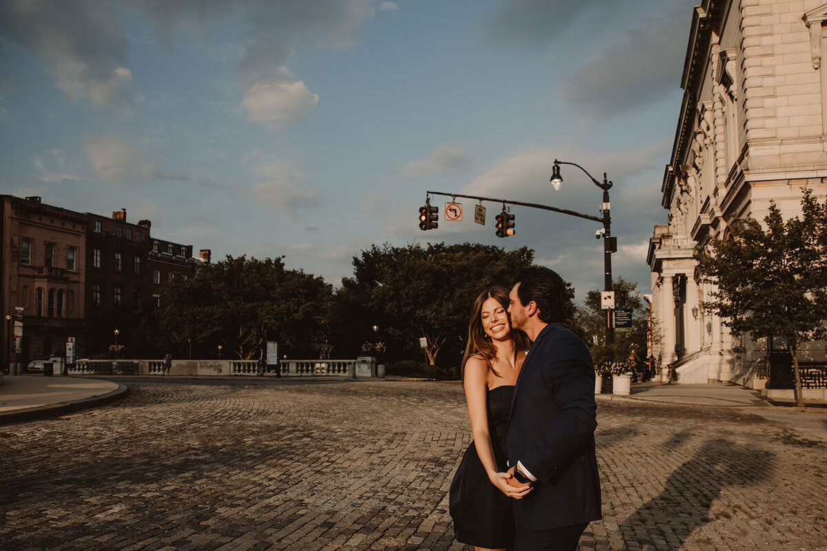 A person kissing their partner's cheek on the street 