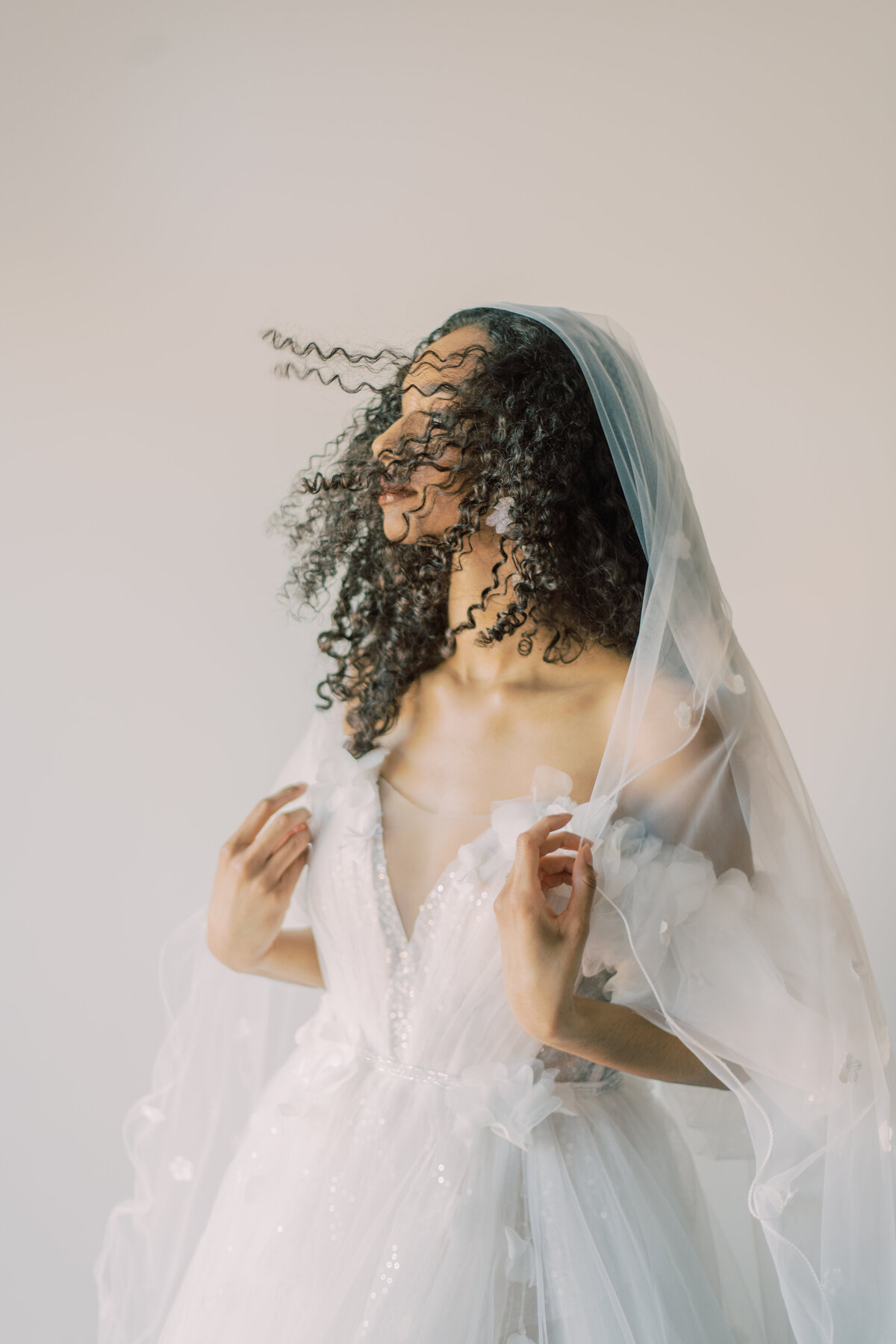 Bride holding veil as the fan takes it in toronto