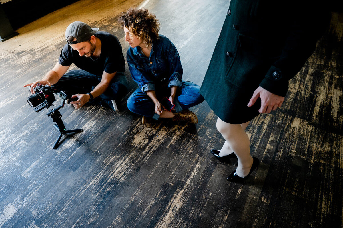 a woman laughing holding the sleeves of her jumper