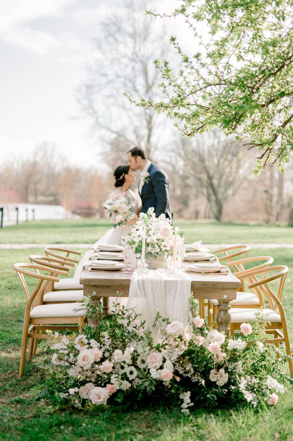 Couple kissing in front of table, wedding photos by Rachael Mattio Photography