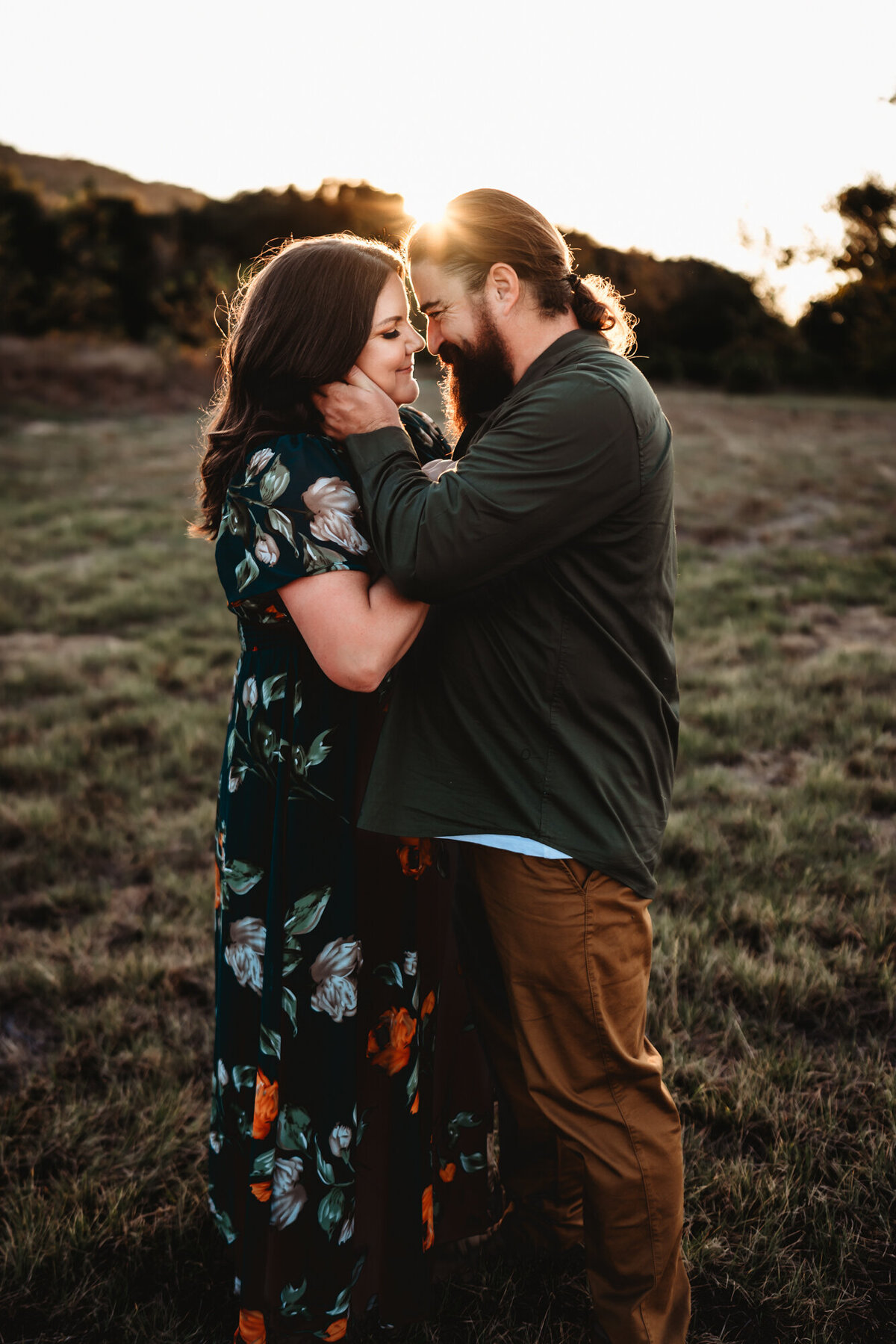 Couple sharing a kiss in a meadow during a San Diego lifestyle photo session.