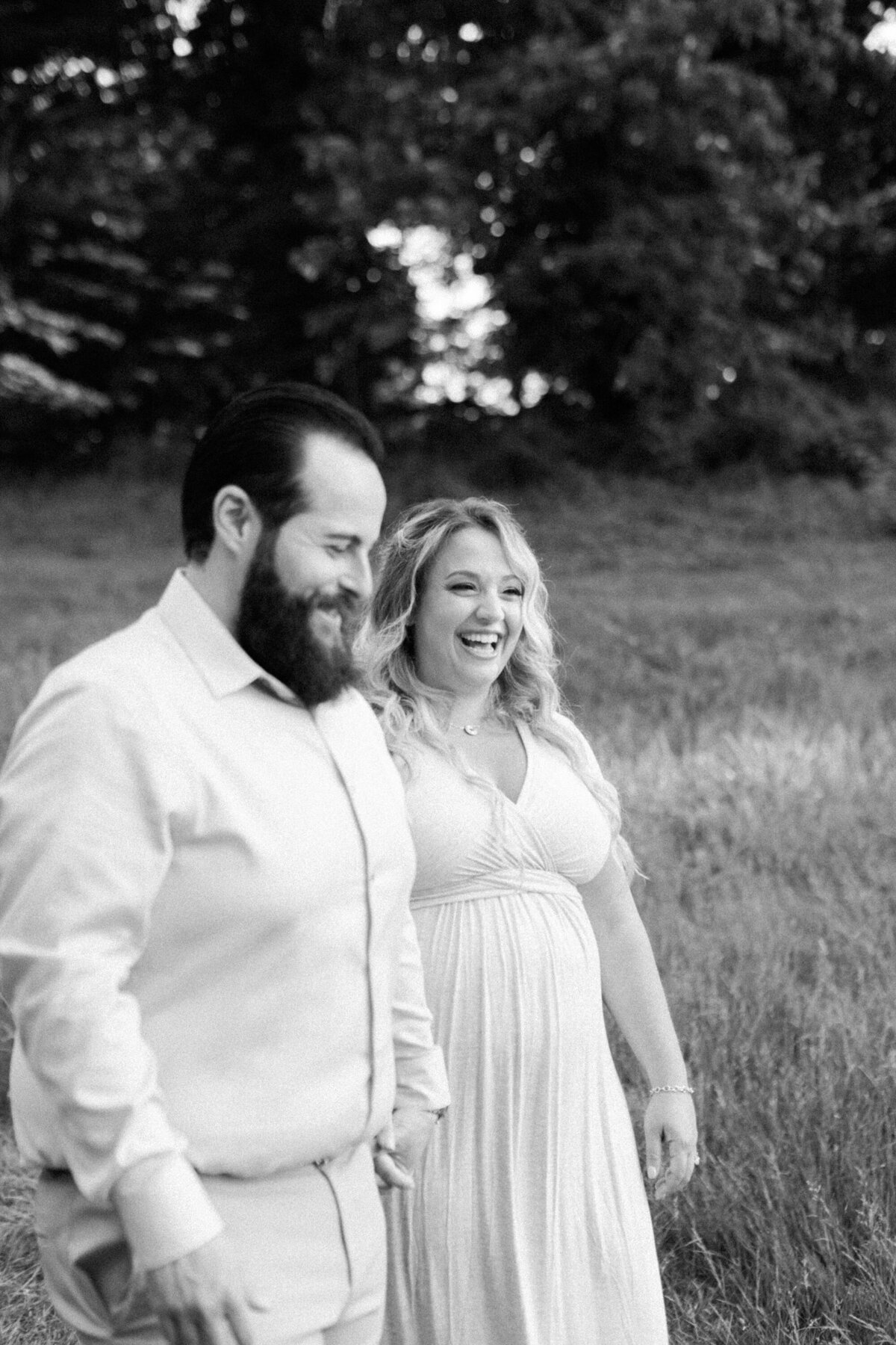 laughing husband and wife expecting in black and white