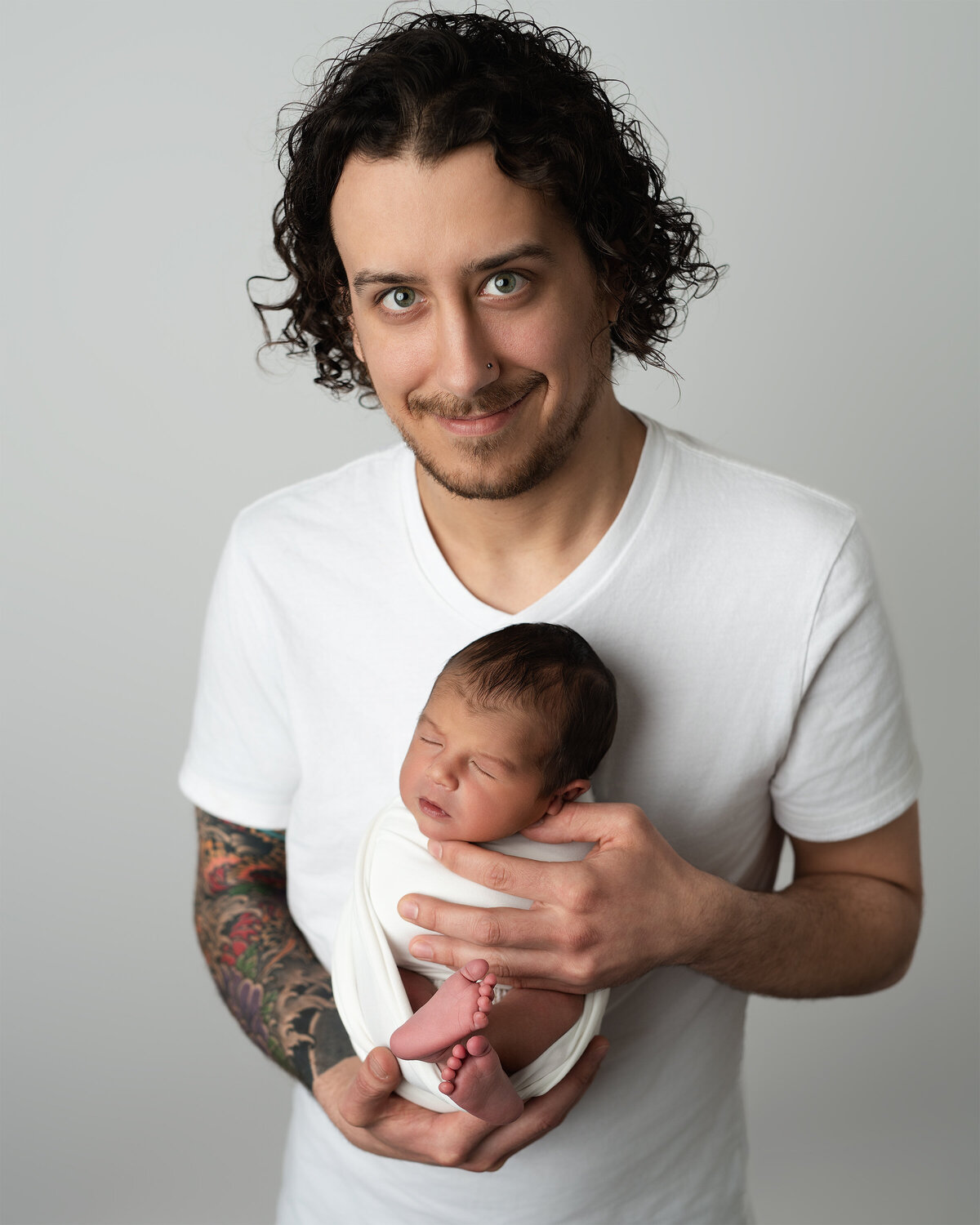 Newborn studio portrait of father holding baby boy | Paris Ontario family photography by Meraki Photographic Creations