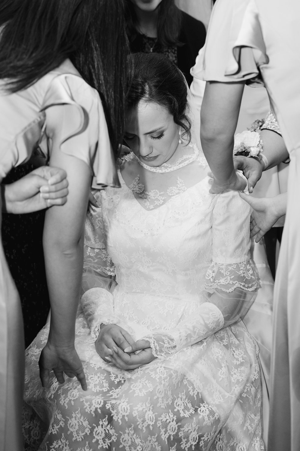 black and white documentary style portrait bride and friends prayer before ceremony