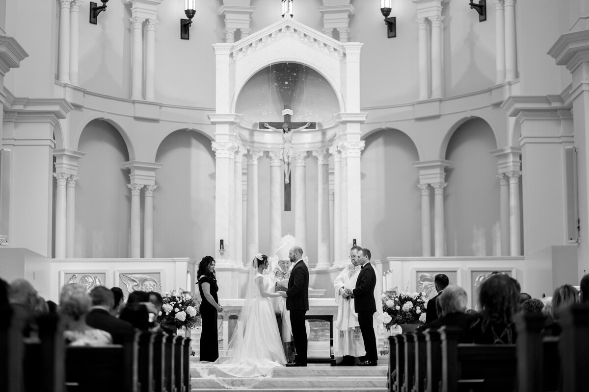 Bride and groom saying their vows in a grand church.
