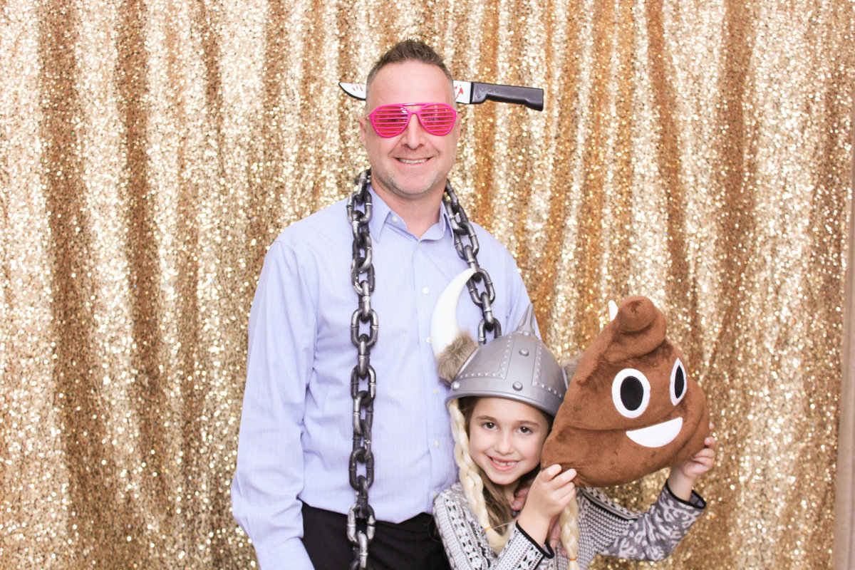 Man poses with a prop knife in his head along with his daughter in a photo booth