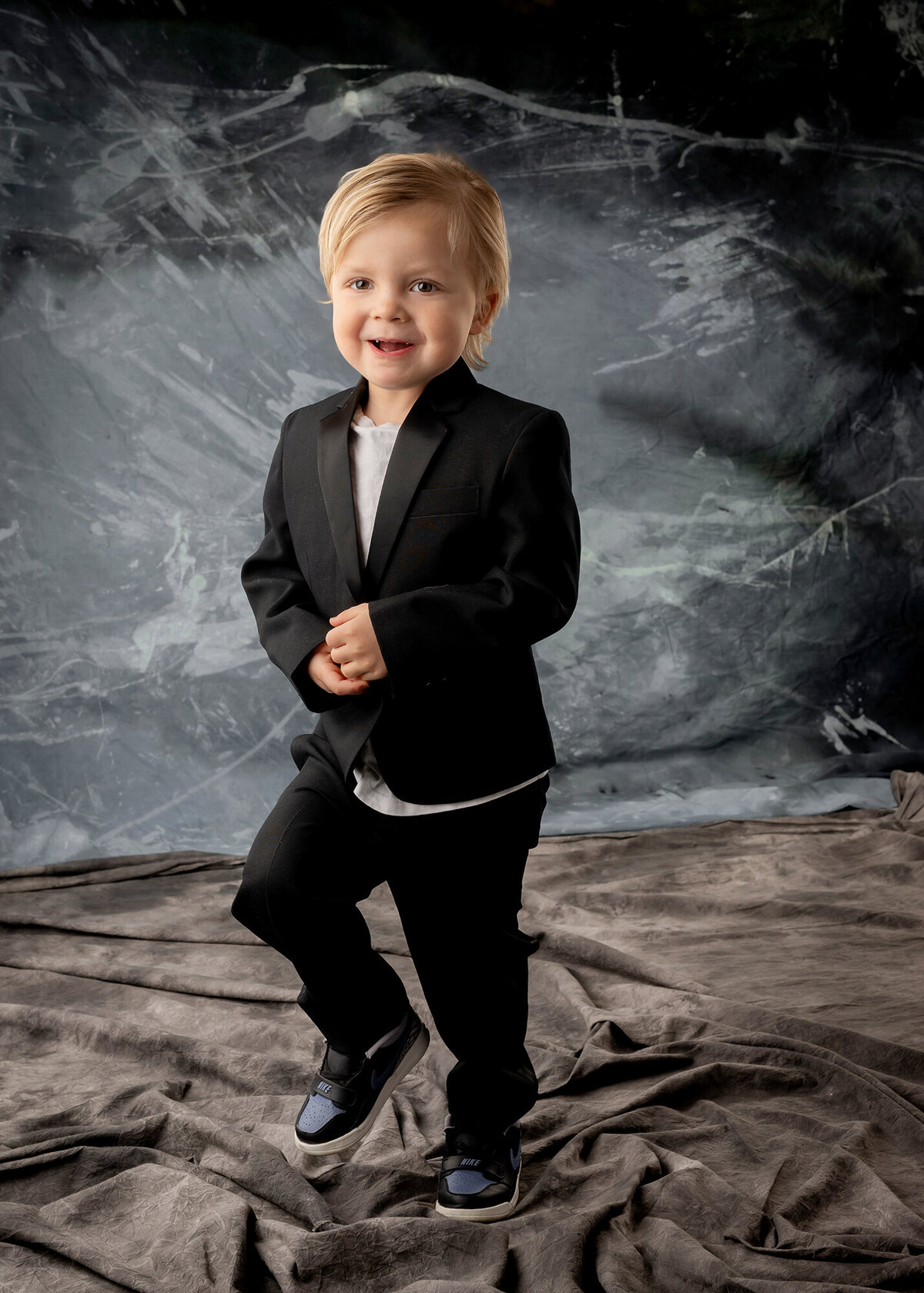 A Pella Family Photographer captures a photo of a toddler boy walking