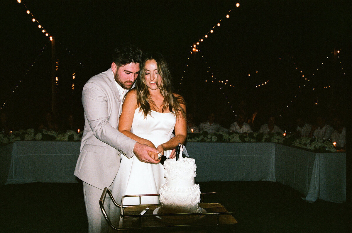 Groom and bride cutting cake shot on 35mm film